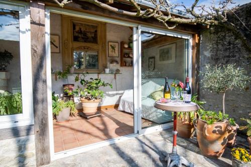 eine Terrasse mit einer Glastür und einem Tisch in der Unterkunft Le Relais de l'Ormeau - Charmant gîte pour 4 pers. in Lussault-sur-Loire
