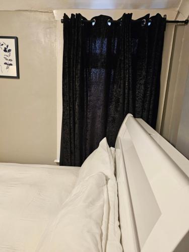 a bedroom with a bed and a black curtain at Umbrella Properties London Excel in London