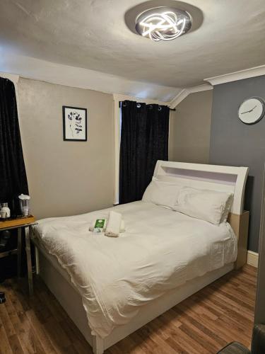 een slaapkamer met een bed met een klok aan de muur bij Umbrella Properties London Excel in Londen