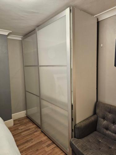 a sliding glass closet in a bedroom with a couch at Umbrella Properties London Excel in London