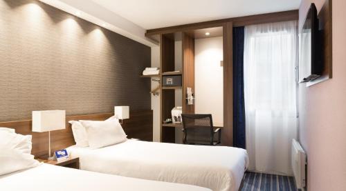 a hotel room with two beds and a desk at Holiday Inn Express Amiens by IHG in Amiens