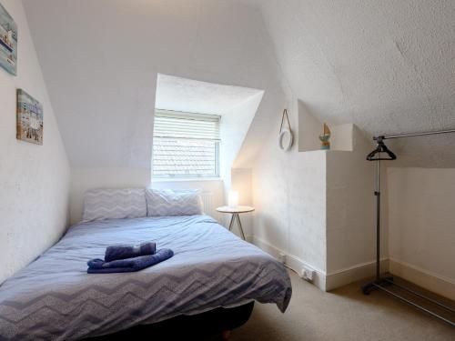 ein Schlafzimmer mit einem Bett mit einer blauen Decke in der Unterkunft 4 Bed in Bournemouth 78807 in Bournemouth