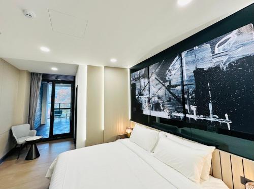 ein Schlafzimmer mit einem Bett mit einem großen Bildschirm darüber in der Unterkunft 水秀一方Sun Moon Lakeside Boutique Hotel in Yuchi