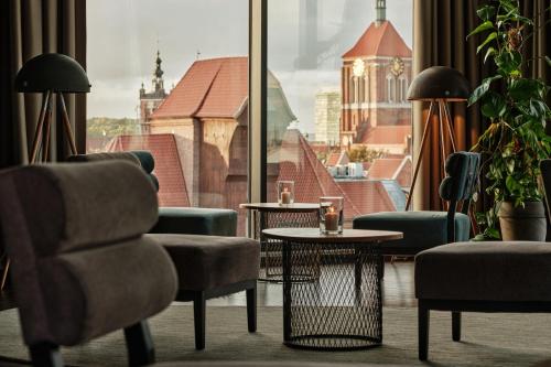 a room with chairs and tables and a large window at Holiday Inn Gdansk - City Centre by IHG in Gdańsk