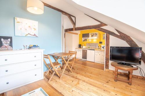 un salon avec une table à manger et une télévision dans l'établissement Au pied du château d'Amboise, à Amboise