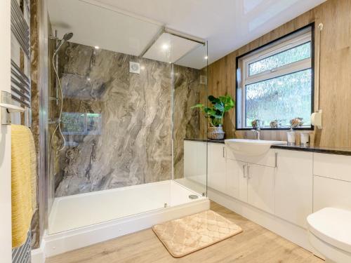 a bathroom with a tub and a sink at 4 Bed in Symonds Yat 79373 in Goodrich