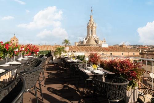 a terrace with tables and chairs on a roof at Palazzo Navona Hotel in Rome