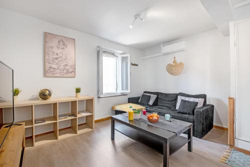 un salon avec un canapé et une table dans l'établissement Les appartements de l'horloge, à Carcassonne