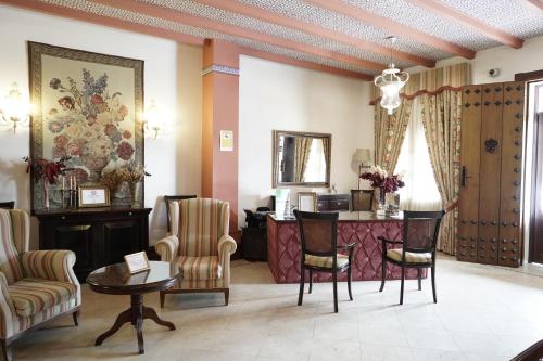 a lobby with a waiting room with chairs and a table at Hospedarte Palacete Real in El Rocío