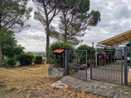 a metal gate with flowers and a tree at A casa della nonna in Seano