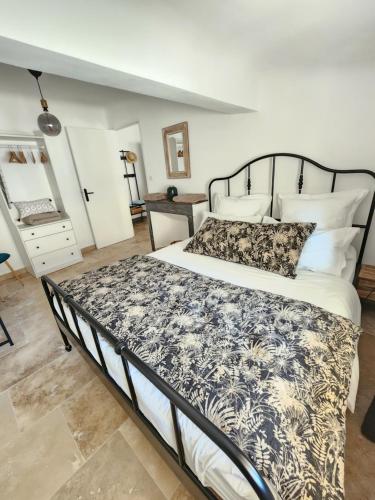 a bedroom with a bed with a black and white comforter at Le Beffroi de Gaston in Aix-en-Provence