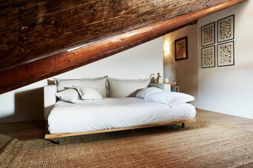 a bed with white sheets and pillows in a room at L’Abbaino in Vicenza