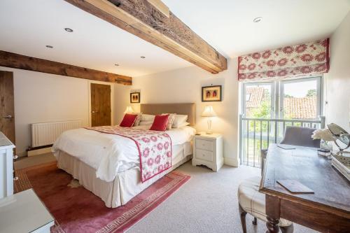 a bedroom with a bed and a window at Christmas Barn in Snettisham