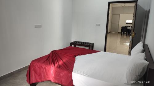 a bedroom with a bed with a red blanket on it at Laxsume Guest House Nilaveli in Nilaveli