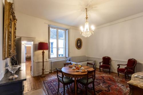 a living room with a table and chairs at L' Hotel de Panette, entrée Renaissance Cathédrale in Bourges
