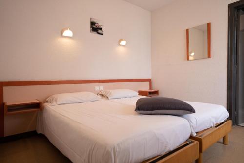 2 camas en una habitación de hotel con sábanas blancas en Azureva Fournols, en Fournols