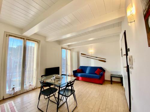 a living room with a blue couch and a glass table at Appartamento vista mare! in Fano