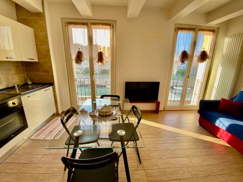 een keuken en een woonkamer met een tafel en stoelen bij Appartamento vista mare! in Fano