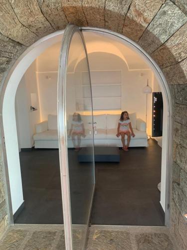 a reflection of a woman sitting on a couch in a mirror at Nido sul mare in Pantelleria
