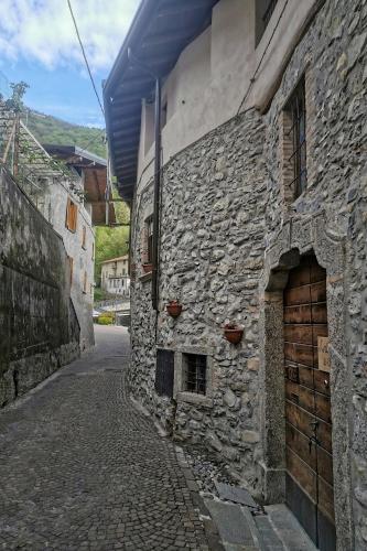 an old stone building with a door on a street at The River Nest in Lasnigo