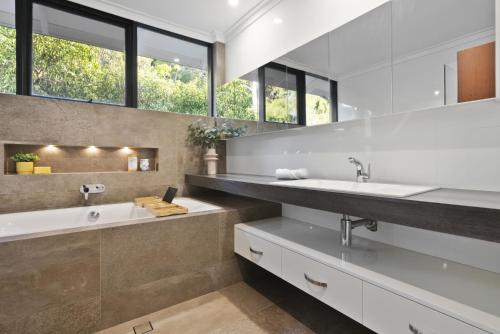 een badkamer met 2 wastafels en een grote spiegel bij REGD1 - Wattle Falls - Perth Hills Escape in Perth