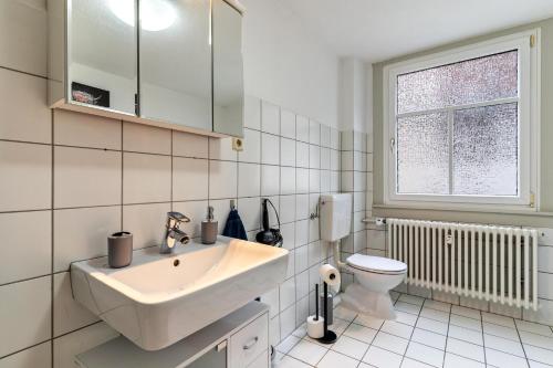 een witte badkamer met een wastafel en een toilet bij Ferienwohnung Joanna in Wolfach