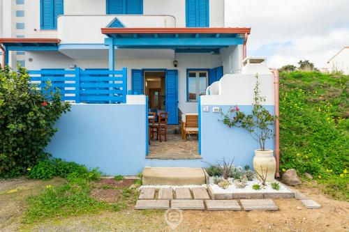 une maison bleue et blanche avec une table dans l'établissement Azure House, à Calasetta