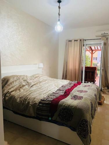 a bedroom with a bed with a quilt on it at SAIDIA AP4 cosy avec piscine in Saidia 