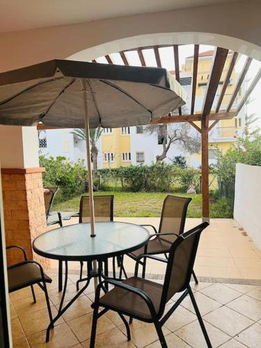 a table and chairs with an umbrella on a patio at SAIDIA AP4 cosy avec piscine in Saidia 