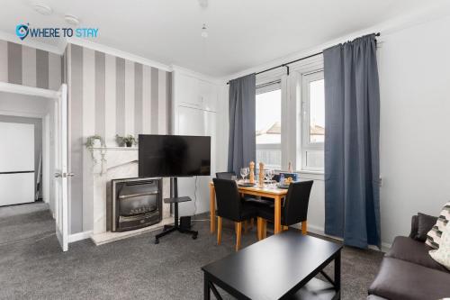 sala de estar con mesa y TV en Secluded 2 bed apartment Edinburgh, en Edimburgo