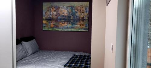 een klein bed in een kamer met een schilderij aan de muur bij Mavrovo Grey Residence in Mavrovo
