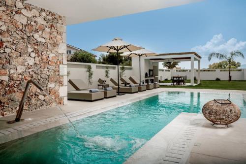 ザキントスにあるVorto Luxury Villas, a Signature Island Retreat, By ThinkVillaのパティオ付きのヴィラ内のスイミングプール