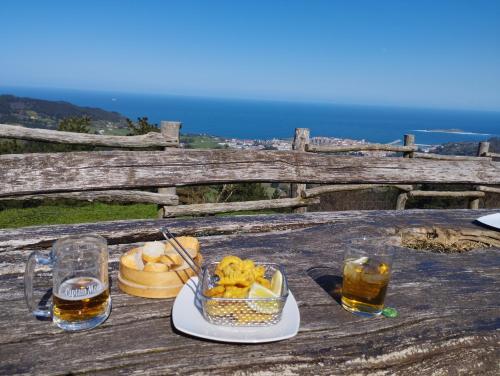 een tafel met een kom eten en twee glazen bier bij Arrantzale Beach in Bermeo