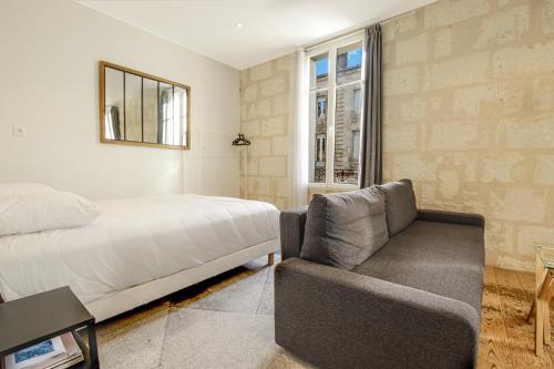 1 dormitorio con 1 cama, 1 silla y 1 ventana en Magnifiques Appartements Climatises En Plein Coeur Des Chartrons, en Burdeos
