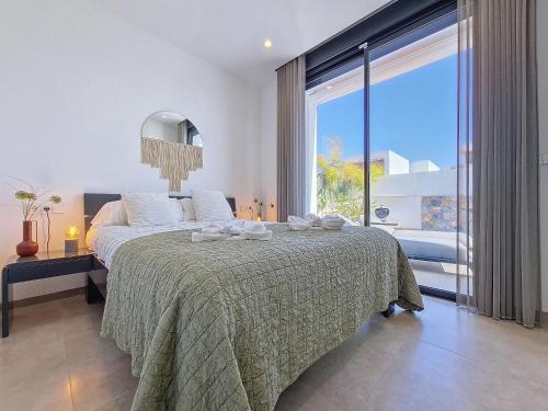 um quarto com uma cama grande e uma janela grande em Villas Alejandra - 8309 em Santiago de la Ribera