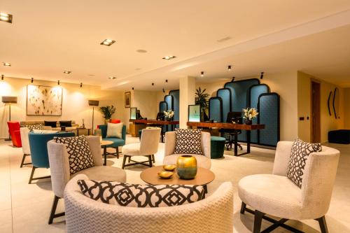 a lobby of a hotel with chairs and tables at MIA Mazagan Bay in El Jadida