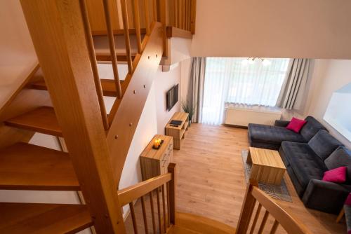 a living room with a couch and a staircase at Malina Apartamenty in Szklarska Poręba