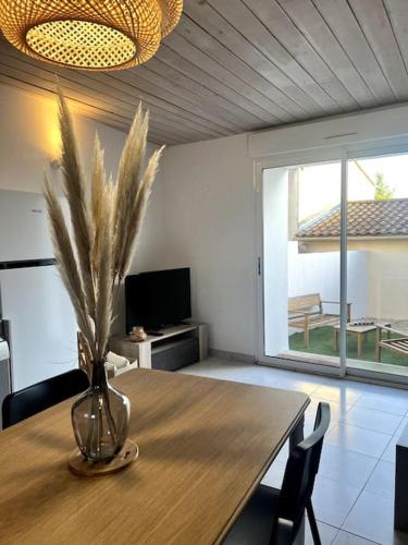 une salle à manger avec une table avec un vase dessus dans l'établissement Puy du fou (10 min) - Nature - T3 L'étape du Puy, aux Herbiers