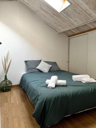 - une chambre avec un lit vert et des serviettes dans l'établissement Puy du fou (10 min) - Nature - T3 L'étape du Puy, aux Herbiers