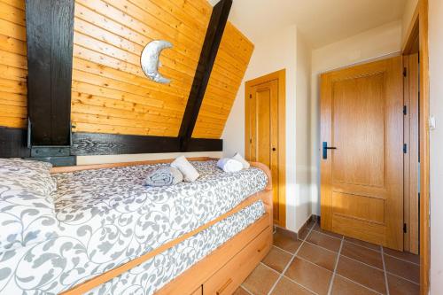 1 dormitorio con 1 cama y pared de madera en Penthouse Luxury Boabdil, en Monachil