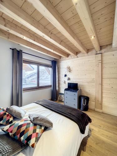 ein Schlafzimmer mit einem großen Bett und einem Fenster in der Unterkunft Chalet Le Daim in La Toussuire