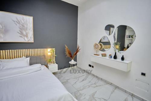 a bedroom with a white bed and a mirror at Luxury Suites in Parakou