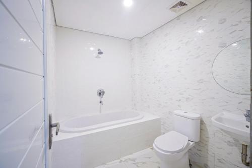 uma casa de banho com uma banheira, um WC e um lavatório. em Habitat@Gandaria em Jakarta