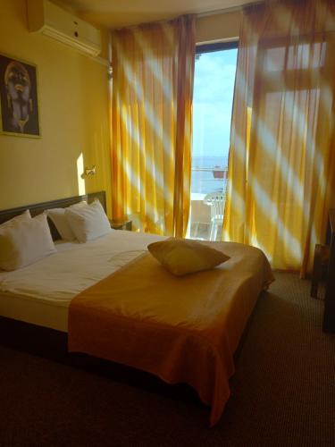 una camera da letto con un letto con una grande finestra di Hotel Blian a Ravda