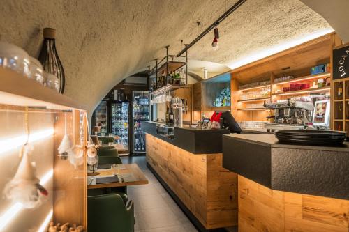 a bar in a restaurant with a counter and chairs at Hotel Diffuso Locanda Elisa in Dimaro