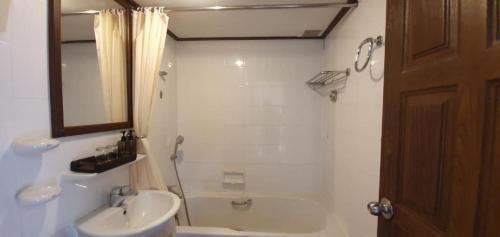 a bathroom with a sink and a toilet and a tub at Isle Beach Resort Krabi-SHA in Klong Muang Beach