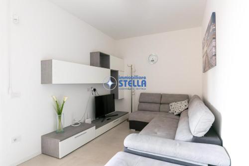 a living room with a couch and a tv at Cala Blu in Lido di Jesolo