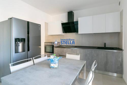 a kitchen with a table with white chairs and a counter at Cala Blu in Lido di Jesolo