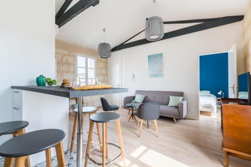 - une cuisine et un salon avec un bar et des tabourets dans l'établissement Magnifiques Appartements Climatises En Plein Coeur Des Chartrons, à Bordeaux