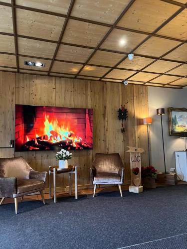 a living room with two chairs and a fireplace at Sportalm Gipfelglück in Lüdenscheid